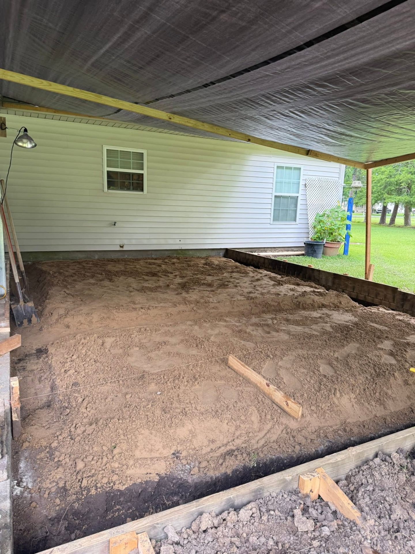 Sand delivered and leveled under a carport pad